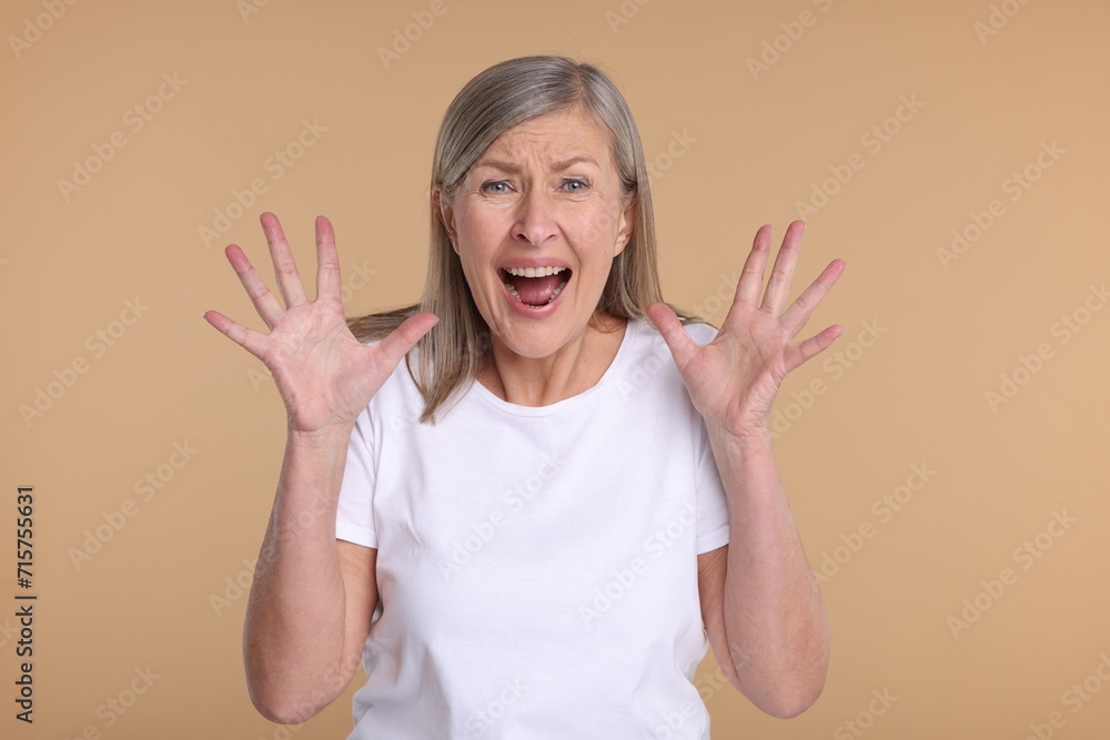 Portrait of surprised senior woman on beige background Portrait of surprised senior woman on beige background