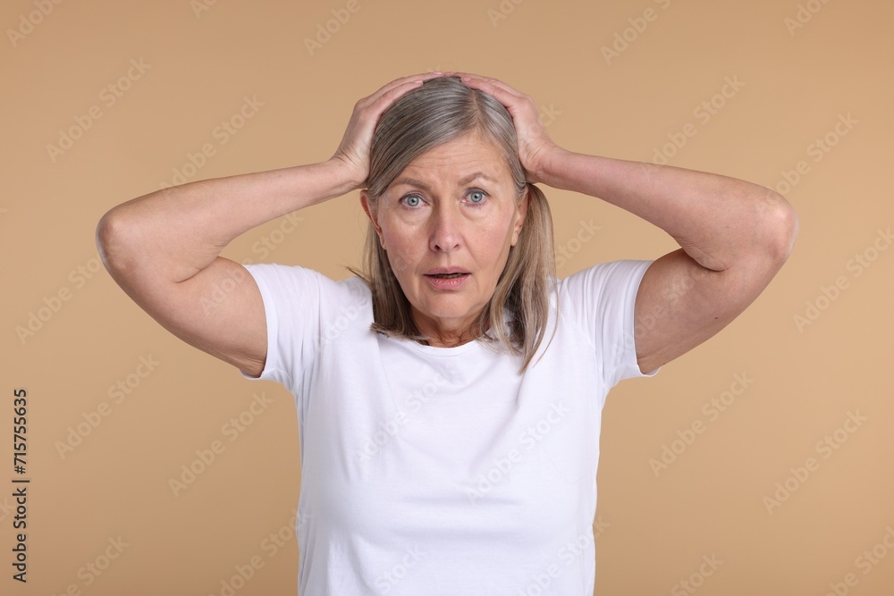 Portrait of surprised senior woman on beige background Portrait of surprised senior woman on beige background
