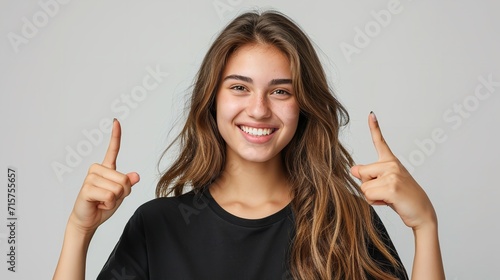 Portrait of an American woman in black t shirt indicating  two forefingers up in a clean backdrop with copy space, Generative AI. photo
