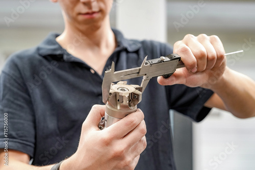 Foto Measuring a cutting tool with a caliper for a CNC machine tool.