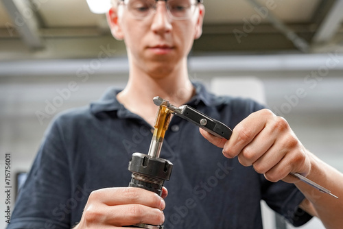 Checking the dimensions of the cutting tool with a caliper for metalworking CNC milling and turning machines.