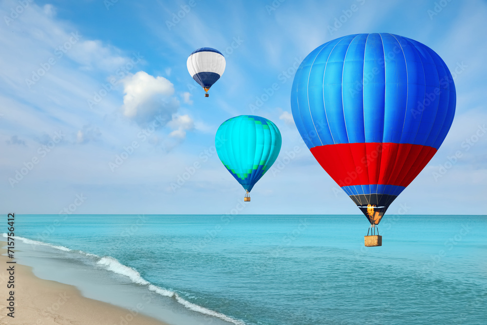 Bright hot air balloons flying over blue sea Bright hot air balloons flying over blue sea