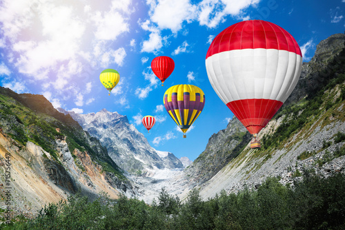 Bright hot air balloons flying in mountains © New Africa
