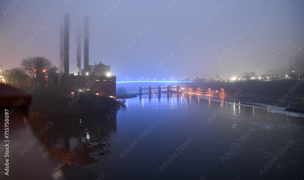 Naklejka premium Illuminated highway road bridge across the river in fog