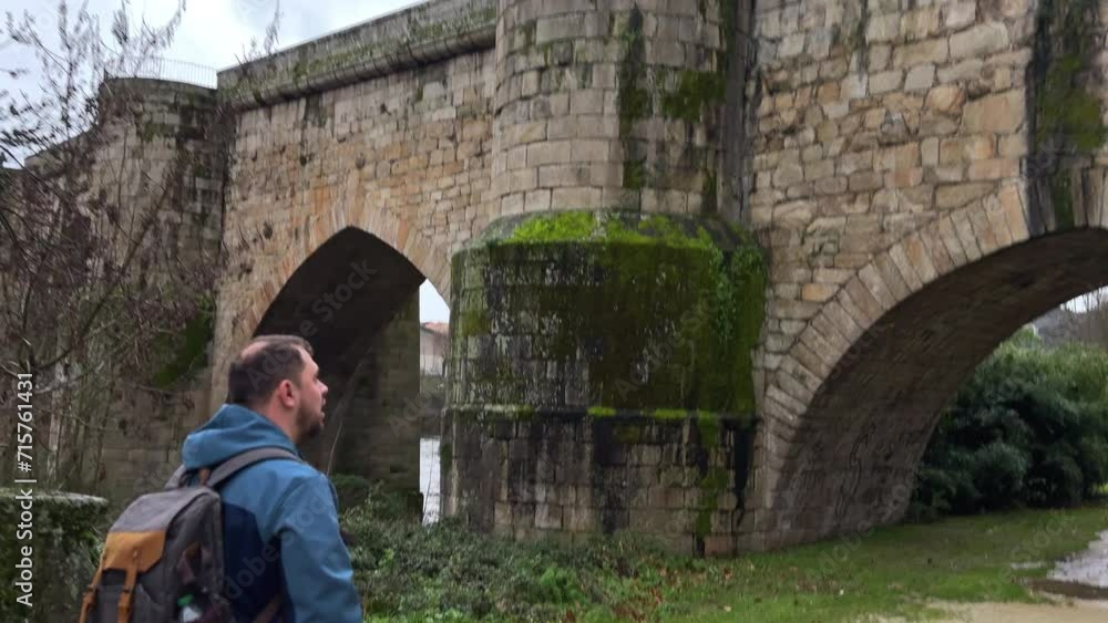 Exploring History: Solo Traveler at a Medieval Bridge Exploring History: Solo Traveler at a Medieval Bridge