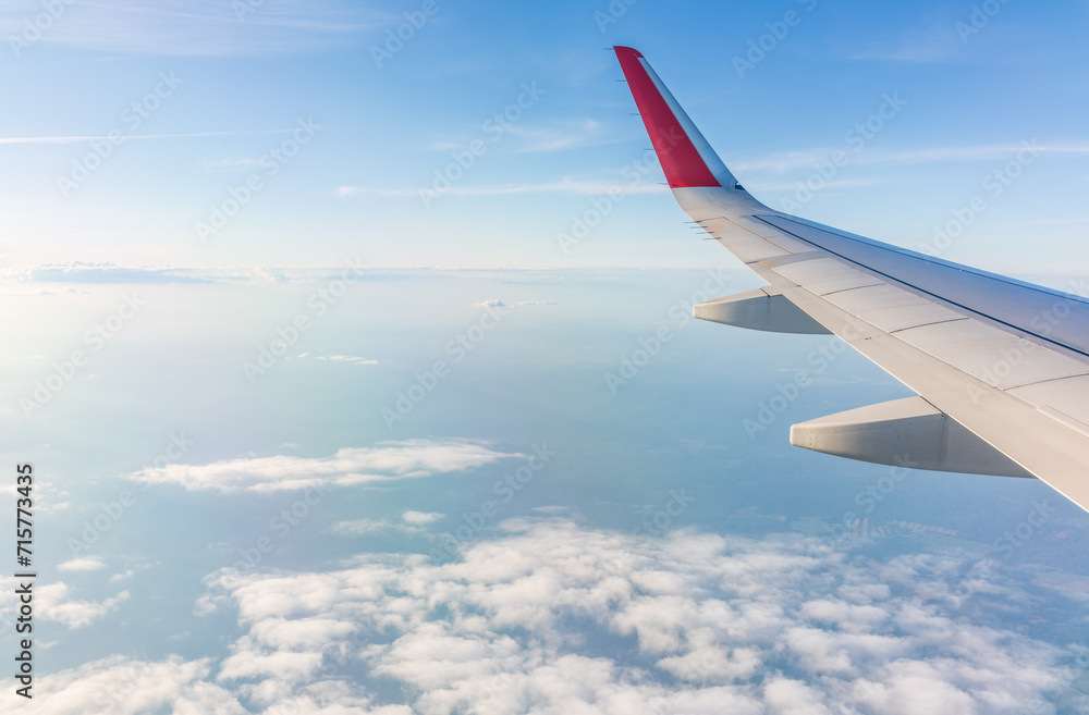 View from the airplane window at a beautiful cloudy sky and the airplane wing View from the airplane window at a beautiful cloudy sky and the airplane wing