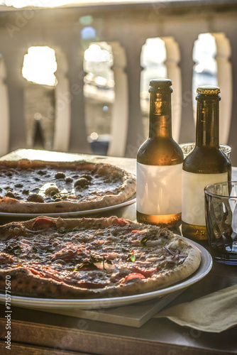 pizze e birre sul tavolino di una pizzeria