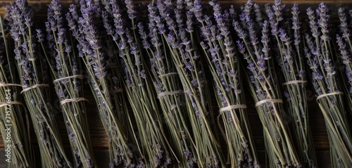  a bunch of lavender flowers sitting next to each other on a wooden table in front of a bunch of other lavender flowers on a wooden table in front of them.