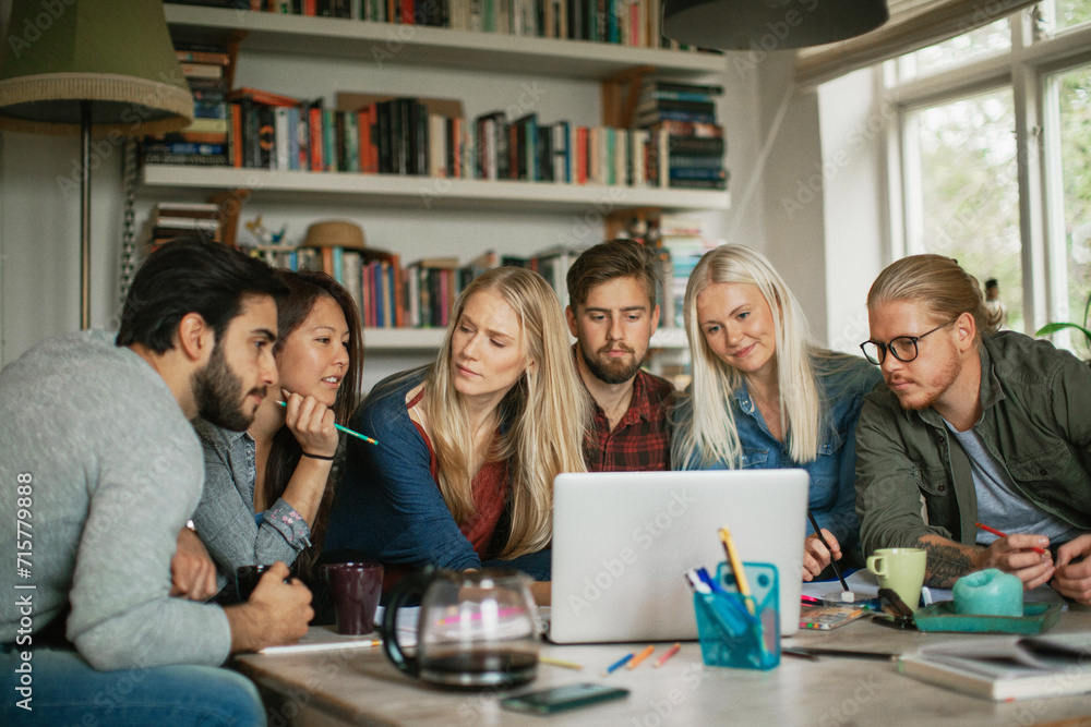 Group of diverse young adults studying together with books and laptop Group of diverse young adults studying together with books and laptop