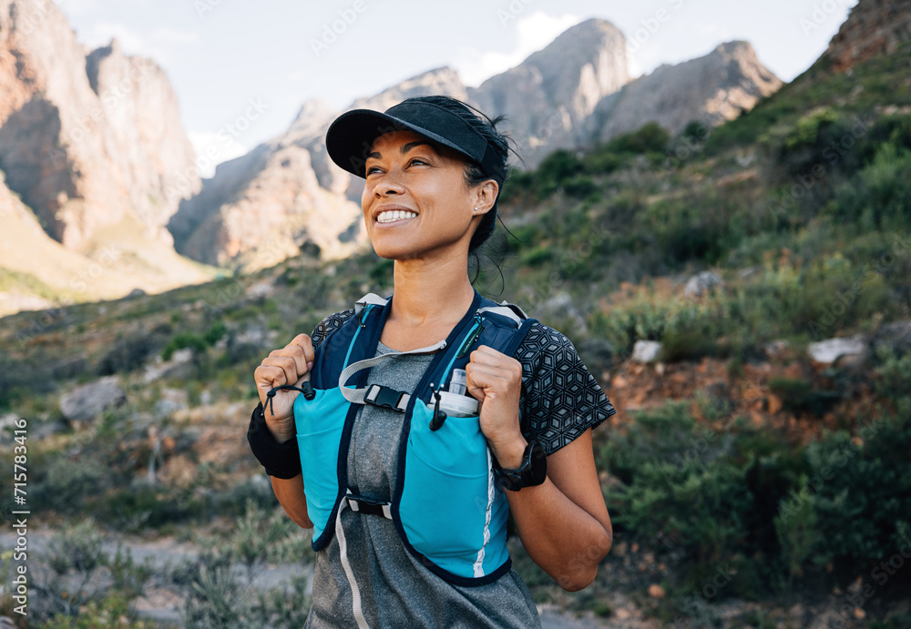 Smiling middle-aged female relaxing during a hike, enjoying the view. Female in hiking sportswear looking on mountains. Smiling middle-aged female relaxing during a hike, enjoying the view. Female in hiking sportswear looking on mountains.