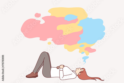 Business woman procrastinates lying on back under multi-colored cloud and not wanting to start working and developing. Girl office employee procrastinates due to lack of ambition or motivation