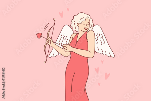 Cupid woman dressed up with wings for valentine day, uses with arrow and bow to seduce boyfriend