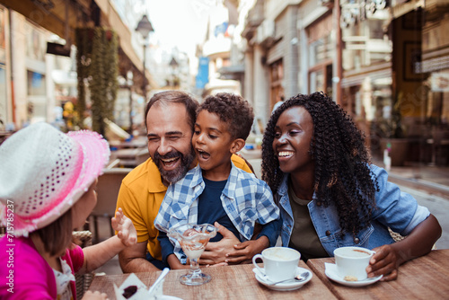 Multicultural family enjoying desserts at an outdoor cafe photo