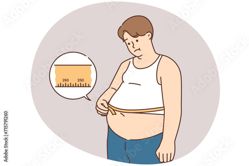 Unhappy fat man measure belly with tape