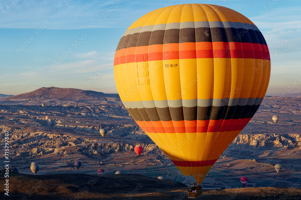 Obraz premium Hot air balloon flight in Goreme in Turkey during sunrise. Ride in a hot air balloon, the most popular activity in Cappadocia. Romantic and famous travel destination.