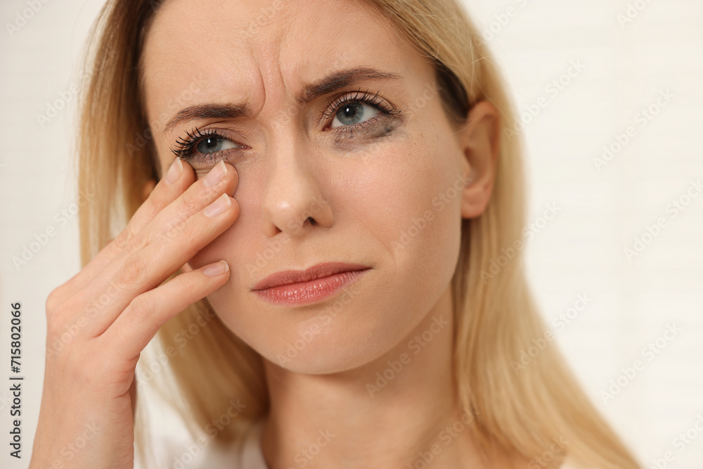 Sad woman with smeared mascara crying indoors, closeup Sad woman with smeared mascara crying indoors, closeup