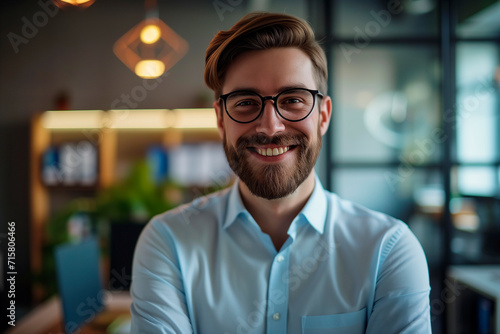 Happy confident businessman in office looking at camera