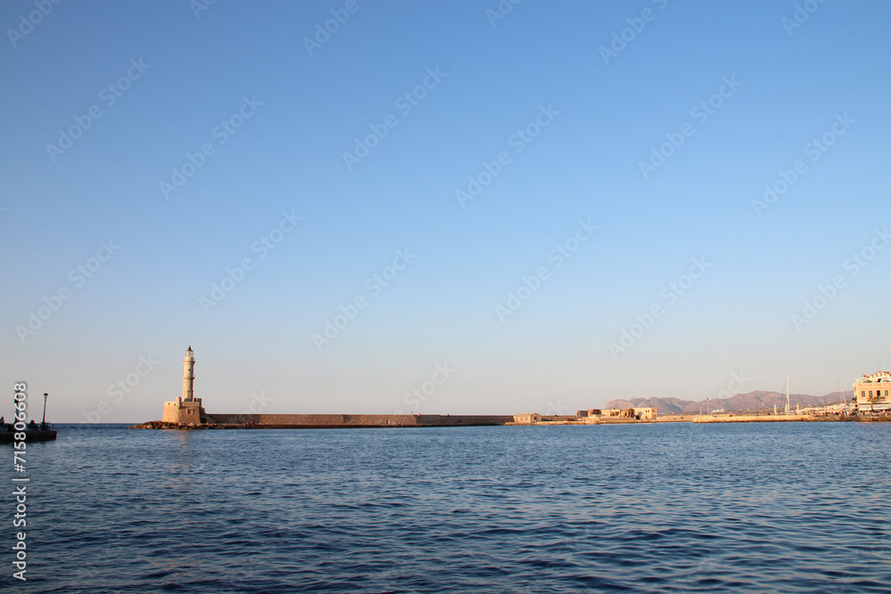 lighthouse, venitian port and mediterranean sea in chania in crete in greece
