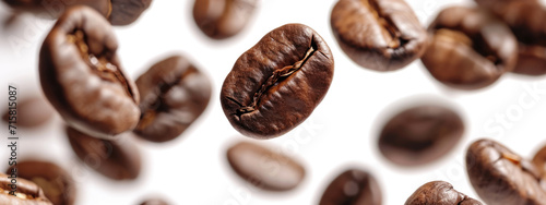 Close-up of scattered roasted coffee beans on a white background, with a central bean in sharp focus.
