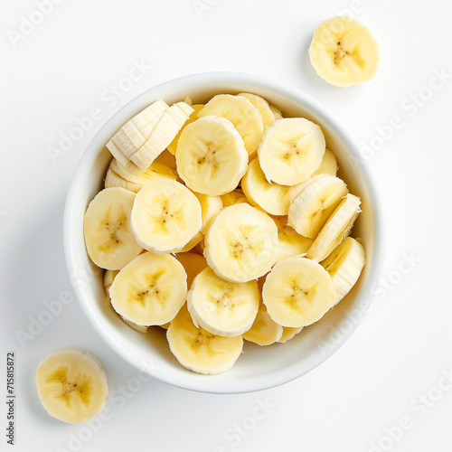 Slices of Bananas in a white bowl on White Background Top Down View Angle
