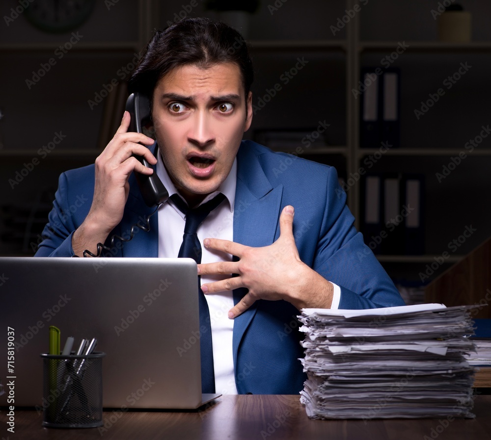 Young male employee working night in the office Young male employee working night in the office
