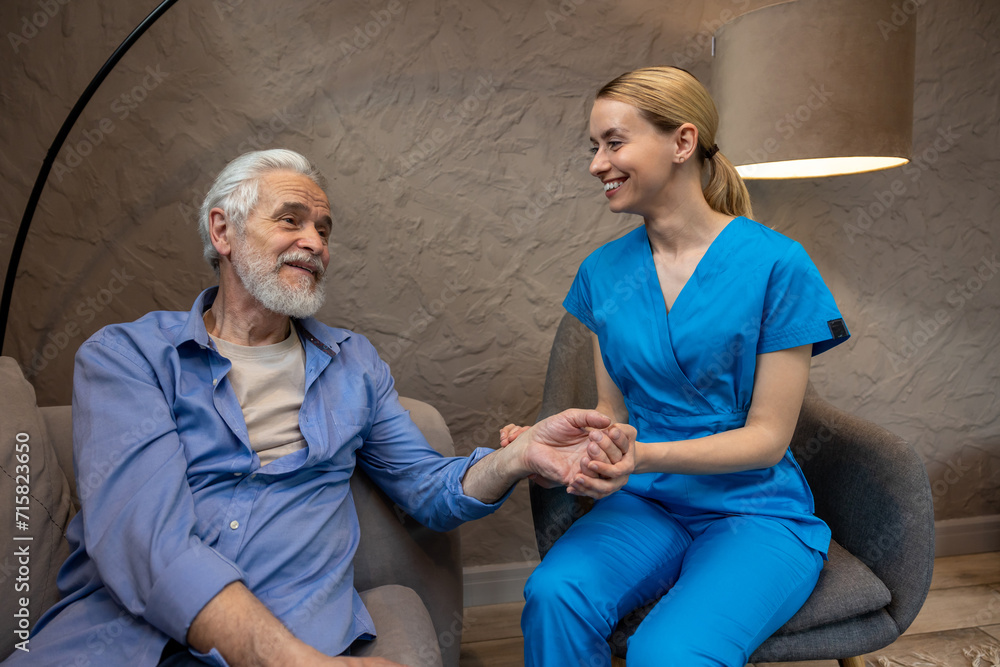 Obraz premium Nurse checking pulse by hand in medical center.