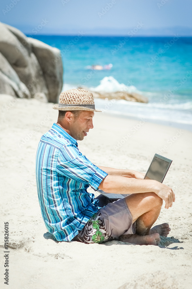 A Happy man guy with laptop near the seashore weekend travel