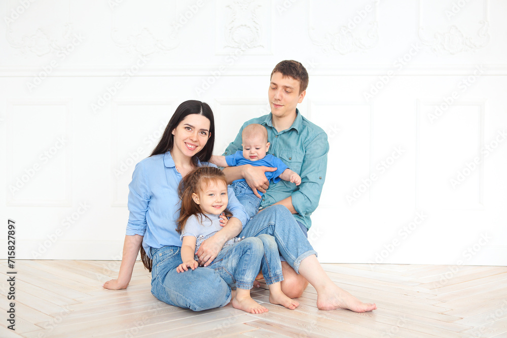 Happy young parents with their adorable little kids at home Happy young parents with their adorable little kids at home