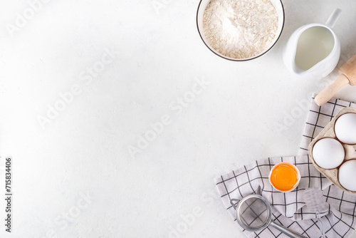 Empty space baking background with bakery ingredients - flour, milk, eggs, rolling pin. Simple pastry baking flat lay top view border