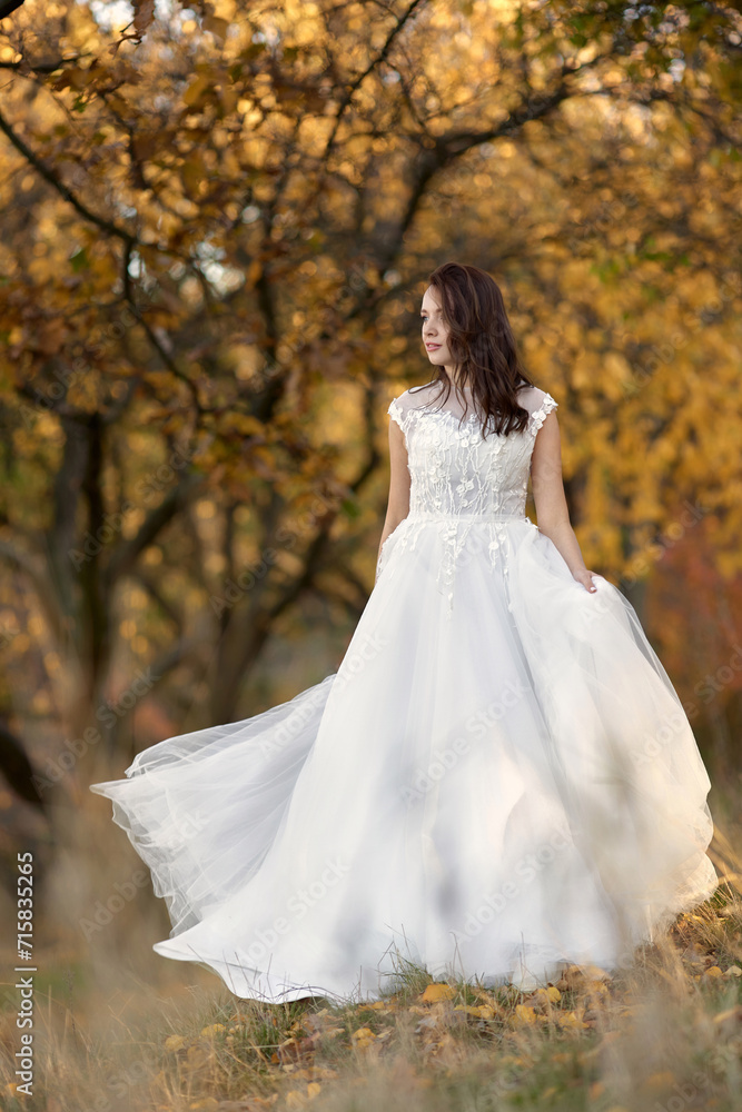 beautiful sensual bride in white wedding dress standing outdoor on natural background