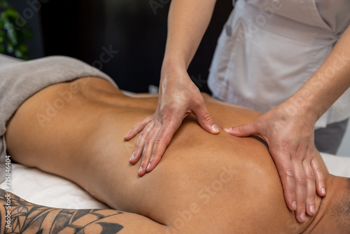 Close up of massage therapist hands doing back massage