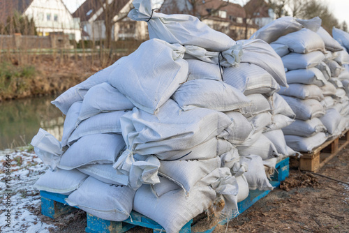 stack of filled sandbags near a river due to floodwater