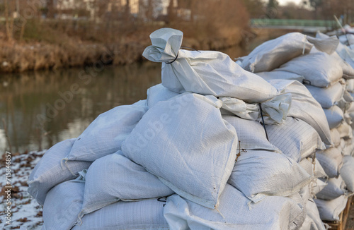 Fotografie stack of filled sandbags near a river due to floodwater