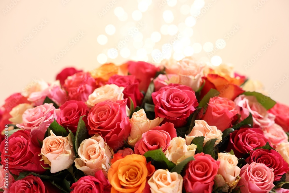 Beautiful bouquet of colorful roses on beige background, closeup