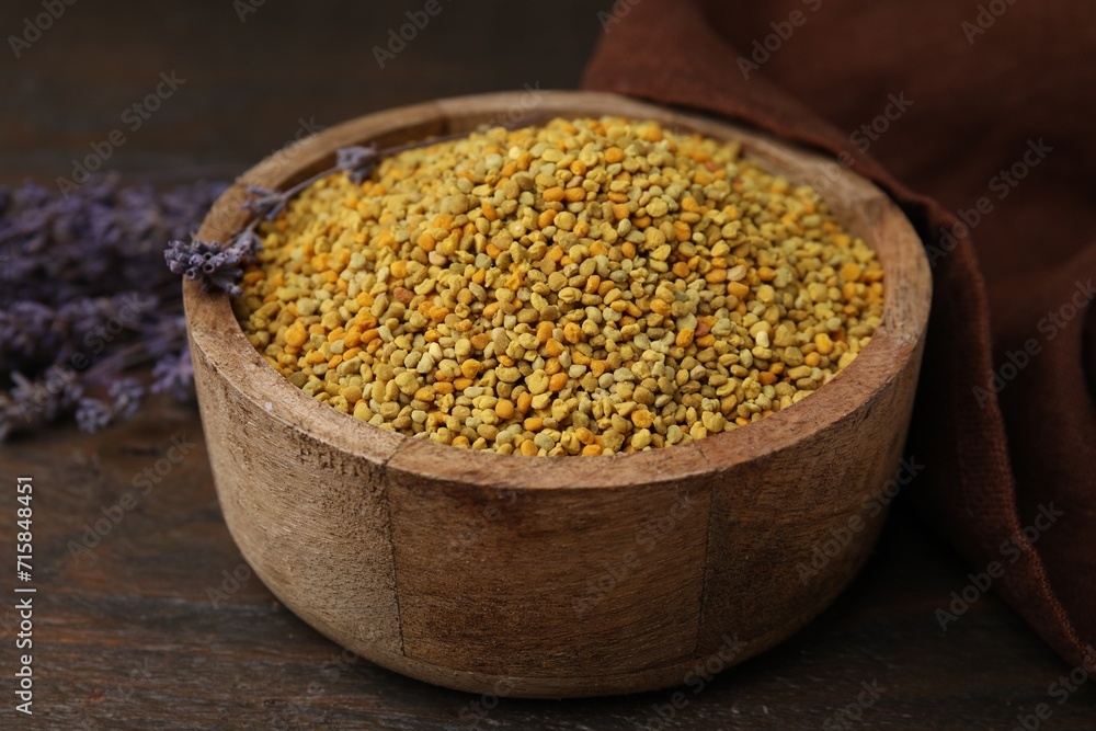 Fresh bee pollen granules in bowl and lavender on wooden table, closeup Fresh bee pollen granules in bowl and lavender on wooden table, closeup