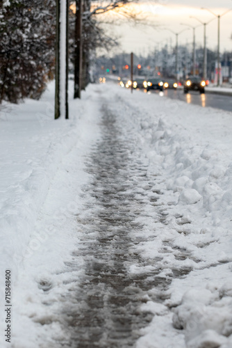 Winter road with melting from salt snow. Close up of sidewalk with slush on snowy day