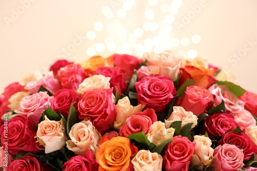 Beautiful bouquet of colorful roses on beige background  closeup