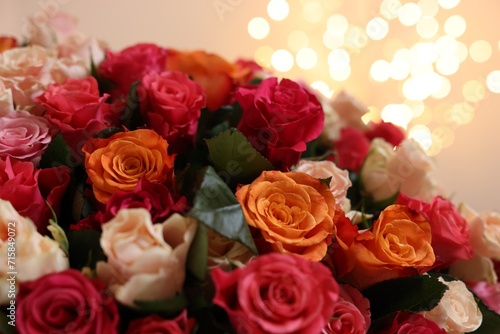 Beautiful bouquet of colorful roses on beige background  closeup