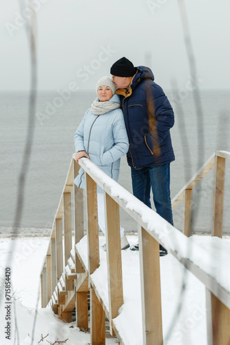Portrait of an elegant elderly couple on a winter snowy day by the sea © Ala