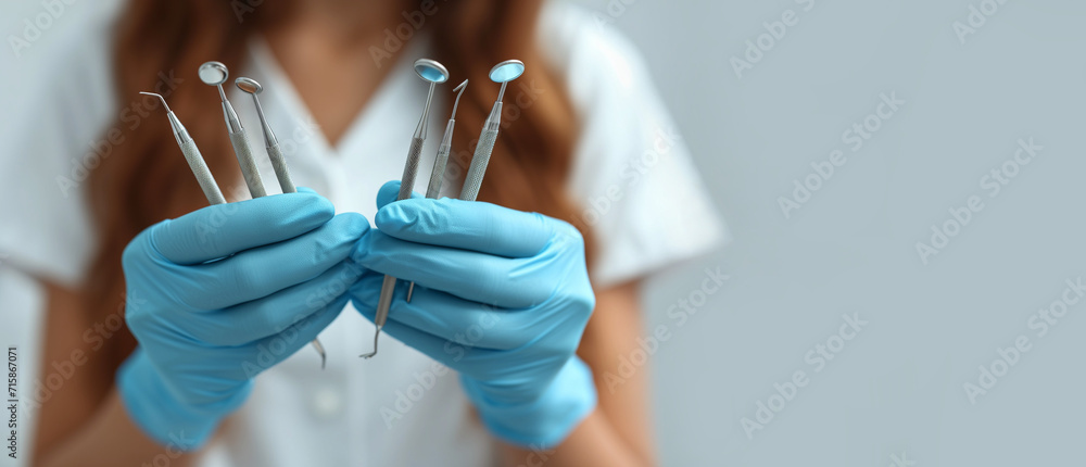 Dentist hands holding dentist mirror, dental instruments on a grey ...