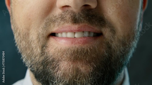 Close up smiling white teeth bearded mid age man on dark grey studio background. Cropped smile handsome man in blue shirt. Successful professional grey haired businessman smiling on bokeh background photo