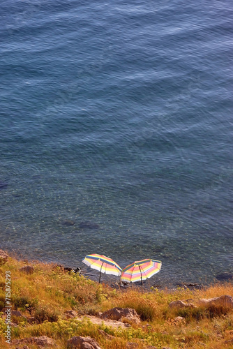 Colorful parasol on the beaach, by the sea. Sunny summer day. Selective focus. photo