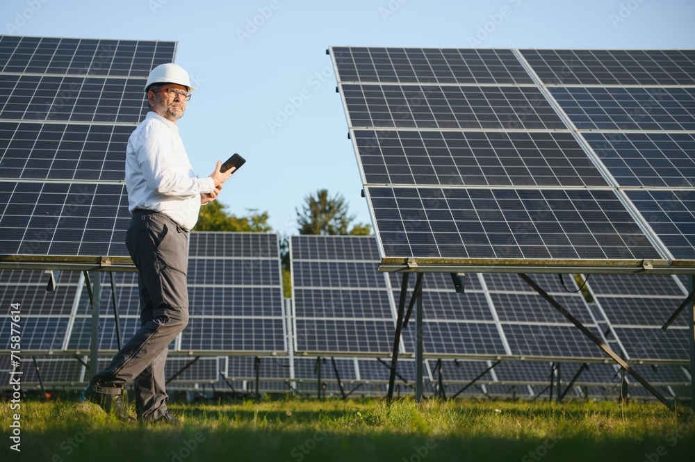 Solar power plant. Man standing near solar panels. Renewable energy Solar power plant. Man standing near solar panels. Renewable energy