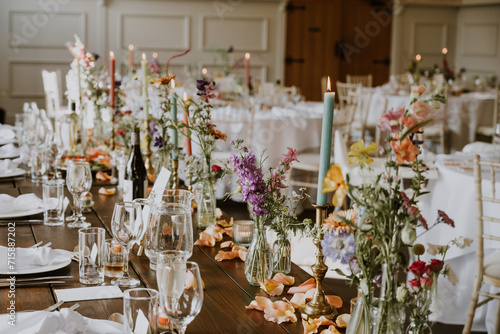 Wedding reception tables decorated with colourful flowers and candles and summery decor