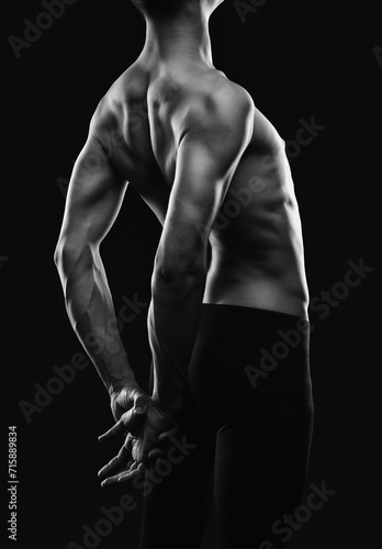 Silhouette of a slender muscular man doing sports in the gym. Sports and healthy lifestyle.