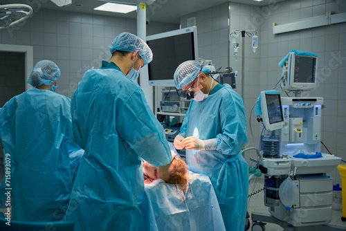 Plastic surgeons perform surgery on a patient