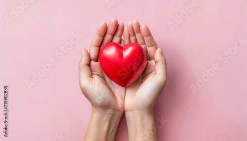 red heart in adult hands on pink background health care organ donation family life insurance world heart day brain stroke