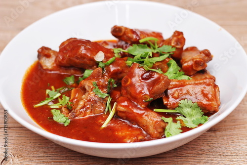 Chinese Red Soup Pork Ribs served on a white plate, a popular Chinese dish, made from sliced pork ribs and tomato sauce.