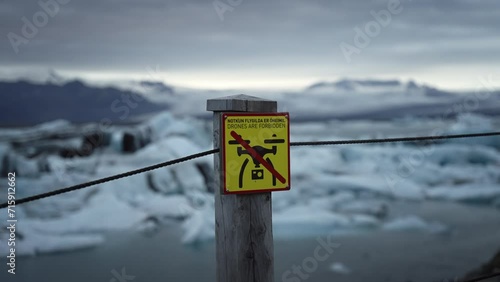 No drones sign in Iceland with icy glaciers and clouds in the background
