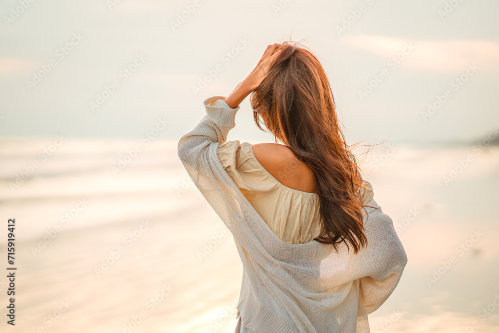 Obraz premium Summer beach vacation concept, Carefree young asian woman relaxing at tropical sea beach during summer vacation, Smiling female enjoying breeze and looking at beach.